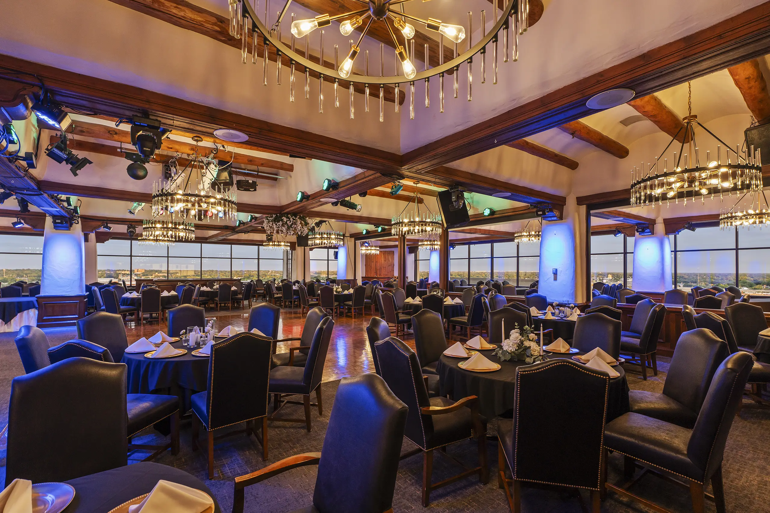 Ninth Floor dining room with chandeliers, table settings, and blue accent lighting